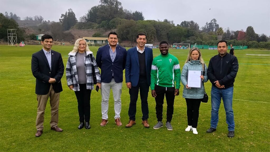 Integrantes de Santiago Wanderers muestran en la cancha su convenio de Compromiso Migrante